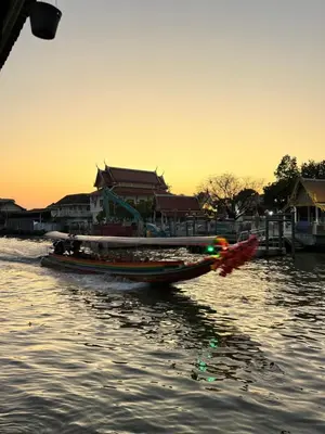 a small boat in the water at sunset at Muzachi home stay and canal in Bangkok Yai