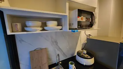 a kitchen with a counter with bowls and a microwave at A3508 Monthly Condo Skytrain Minutes away Full Kitchen and Bath! in Bangkok