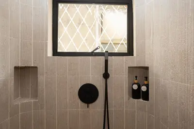a window in a shower with two bottles on the wall at 2 Bedroom for 4 Guests Private at Center Sathorn in Bangkok