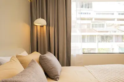 a bedroom with a bed with pillows and a window at 2 Bedroom for 4 Guests Private at Center Sathorn in Bangkok