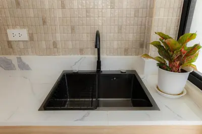 a sink in a kitchen with a potted plant at Studio for 3 Guests with Kitchen at Center Sathorn in Bangkok