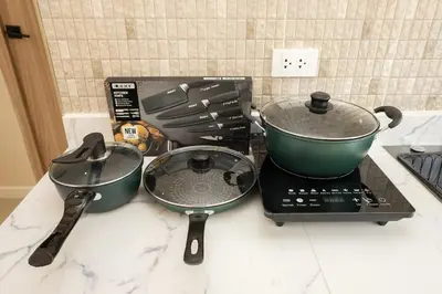 a stove with two pans and a pot on it at Studio for 3 Guests with Kitchen at Center Sathorn in Bangkok