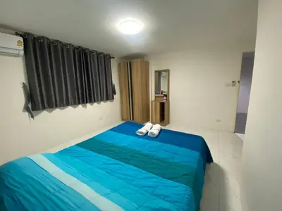 a bedroom with a blue bed with white shoes on it at PN Apartment At Udomsuk 47
