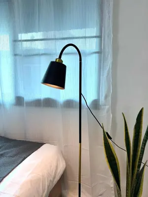 a black lamp sitting next to a bed with a plant at Bonvie Residence in Thung Maha Mek