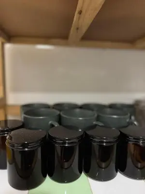 a row of black cups sitting on a shelf at Bonvie Residence in Thung Maha Mek