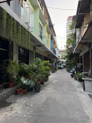 an empty street with potted plants and buildings at Bonvie Residence in Thung Maha Mek