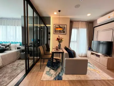 a living room with a couch and a table in a room at New Luxury Condo 5 Min Onnut BTS - Modiz Sukhumvit 50 in Bangkok
