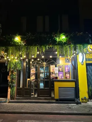 a restaurant on a street at night at Lesbase Women Hostel in Bangkok