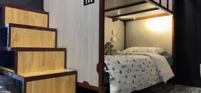 a bedroom with a bed with a white comforter at Lesbase Women Hostel in Bangkok