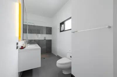 a white bathroom with a toilet and a sink at Thong Lo Modern Pool Villa In Center Of Bangkok in Bangkok