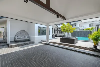 an outdoor patio with a couch and a swimming pool at Thong Lo Modern Pool Villa In Center Of Bangkok in Bangkok
