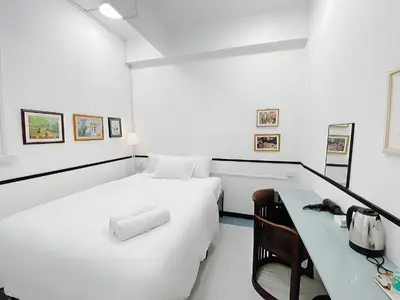 a white room with a bed and a desk at xx GO INN MRT Hua Lamphong - วัดไตรมิตร in Samphanthawong