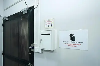 a white machine with a sign on a wall at xx GO INN MRT Hua Lamphong - วัดไตรมิตร in Samphanthawong