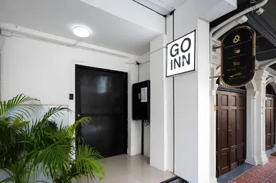 a black door in a white building with plants at xx GO INN MRT Hua Lamphong - วัดไตรมิตร in Samphanthawong
