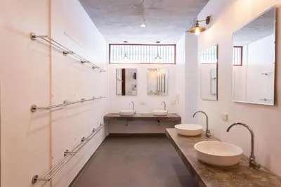 a bathroom with two sinks and two mirrors at Once Again Hostel in Bangkok