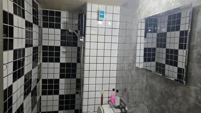 a bathroom with black and white tiled walls and a mirror at อิมแพ็ค เมืองทองธานี ห้องเช่ารายวัน เมืองทอง คอนโดเมืองทอง c9