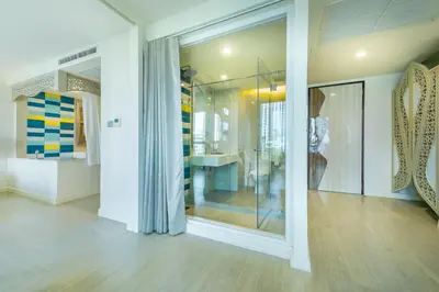a room with a large glass window with a table at Le Tada Parkview Hotel in Bangkok