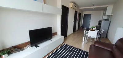 a living room with a flat screen tv on a wall at Sky Walk Condo Spacious 2BR Near BTS Phra Khanong in Bangkok