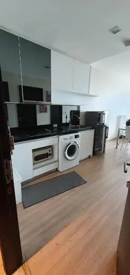 a kitchen with white appliances and a wooden floor at Sky Walk Condo Spacious 2BR Near BTS Phra Khanong in Bangkok