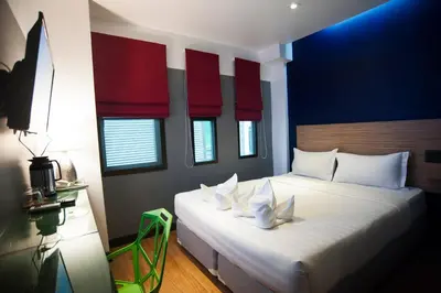 a bedroom with a large bed with red and blue walls at Cloud 9 Lodge in Bangkok
