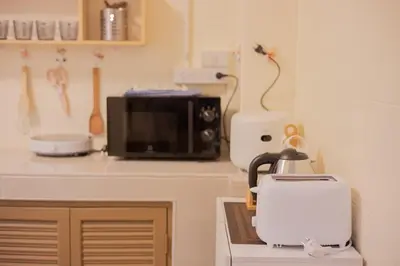 a kitchen with a microwave and a coffee maker on a counter at Warm & Cozy Family Home, Near BTS Punnawithi in Phra Khanong