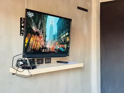 a flat screen tv sitting on a shelf on a wall at Bangkok Phattanakan32 guest house in Bangkok