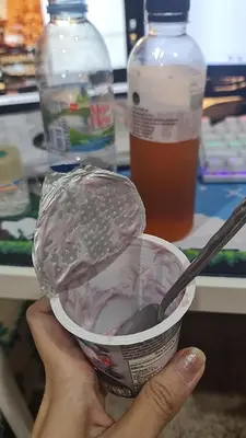 a person holding a cup with a spoon in it at Lionkey in Taling Chan