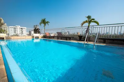a large blue swimming pool on top of a building at Sathorn Garden View in Bangkok