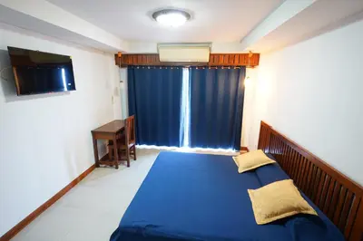 a bedroom with a blue bed and a window at Sathorn Garden View in Bangkok