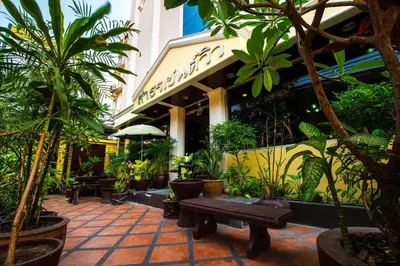 a patio with plants and a bench in front of a building at Sathorn Garden View in Bangkok