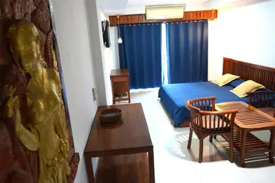a bedroom with a bed and a table and a dining room at Sathorn Garden View in Bangkok