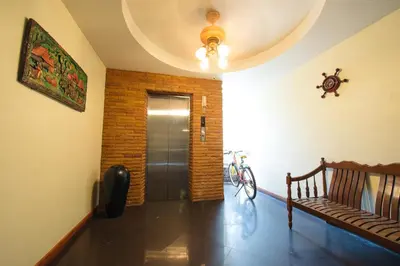 a hallway with a door and a bench in a room at Sathorn Garden View in Bangkok