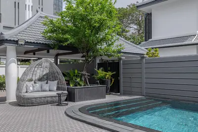 a backyard with a swing and a swimming pool at Thong Lo Luxury Pool Villa In Center Of Bangkok in Bangkok