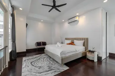 a bedroom with a bed and a ceiling fan at Thong Lo Luxury Pool Villa In Center Of Bangkok in Bangkok