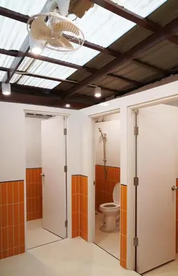 a bathroom with a toilet and a ceiling at Nitra Hostel Siriraj in Bangkok