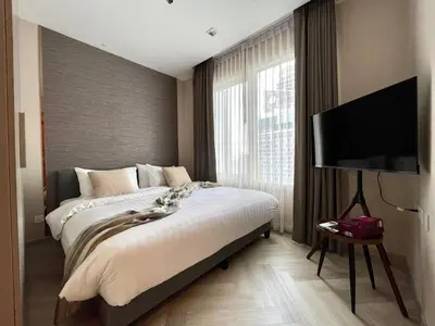 a bedroom with a large bed and a flat screen tv at Supreme Spacious 2-Bedroom in Prime Location! BTS Thonglor in Bangkok