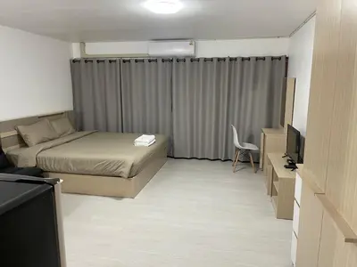 a small bedroom with a bed and a television at Hi Impact Muangthong T9 in Nonthaburi