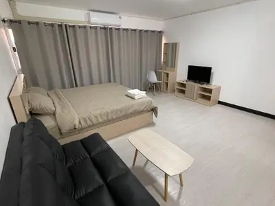a bedroom with a bed and a couch and a tv at Hi Impact Muangthong T9 in Nonthaburi