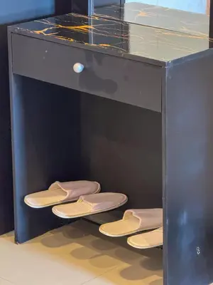 a shelf with three pairs of sandals on the floor at POR SAHA Hotel Ramkhamhaeng 100 in Bang Kapi