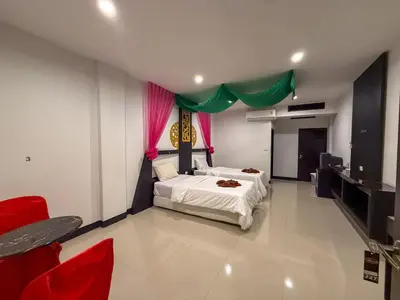a bedroom with a bed and some red chairs at POR SAHA Hotel Ramkhamhaeng 100 in Bang Kapi