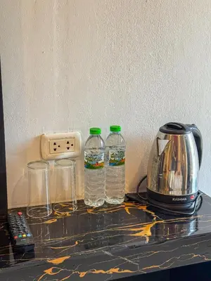 a counter with two bottles of water and a toaster at POR SAHA Hotel Ramkhamhaeng 100 in Bang Kapi