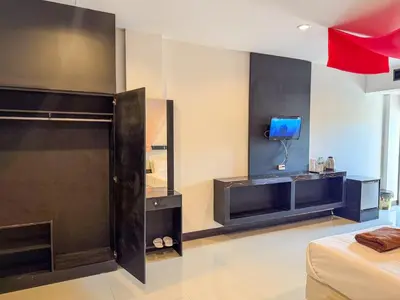 a bedroom with a bed and a tv on a wall at POR SAHA Hotel Ramkhamhaeng 100 in Bang Kapi