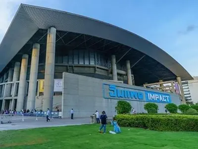 a large building with people standing outside of it at CT Impact in Thung Si Kan