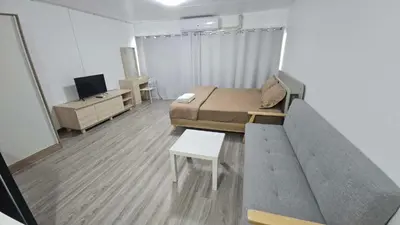 a small room with a bed and a couch at CT Impact in Thung Si Kan