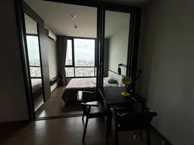 a bedroom with a bed and a desk and a large window at High Rise Designer Gem Central Bangkok City View in Bangkok
