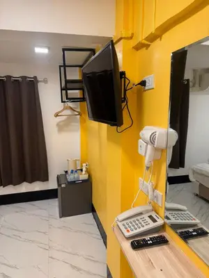 a room with a tv on a yellow wall at Siam Boutique Hotel in Bangkok