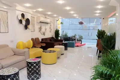 a living room with a couch and tables and chairs at Siam Boutique Hotel in Bangkok