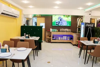 a restaurant with tables and chairs and a tv at Siam Boutique Hotel in Bangkok
