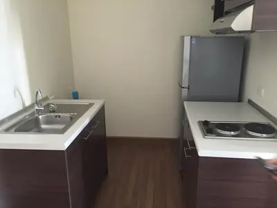 a small kitchen with a sink and a refrigerator at SS Sukhumwit in Amphoe Phra Khanong
