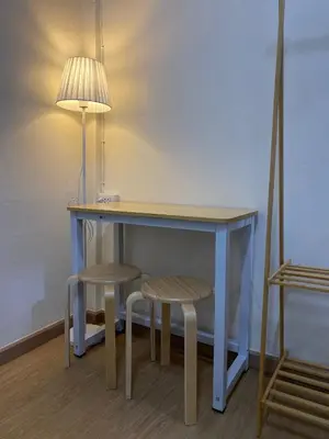 a table with two stools and a lamp and a table with a table at PAMA'Pranakorn in Bangkok